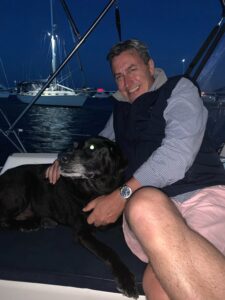 Photo of Patrick Canavan on a sailboat with his dog, Zoey.